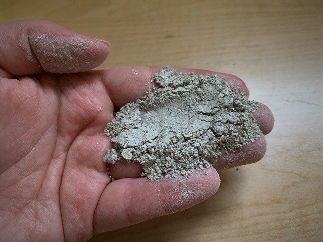 Mussel shell temper in a hand to show fine powder texture. 